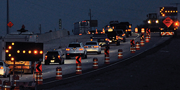 Busy nighttime highway work zone.