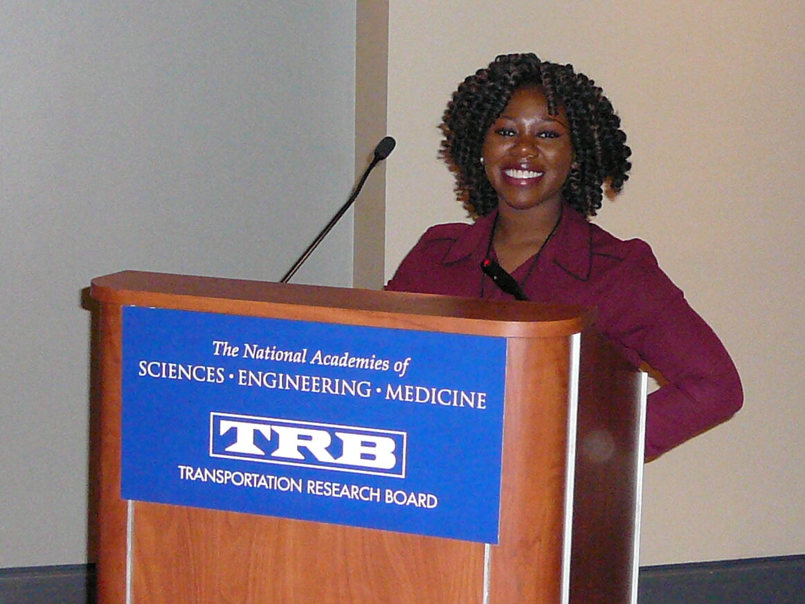 A student smiles while standing at the TRB podium.